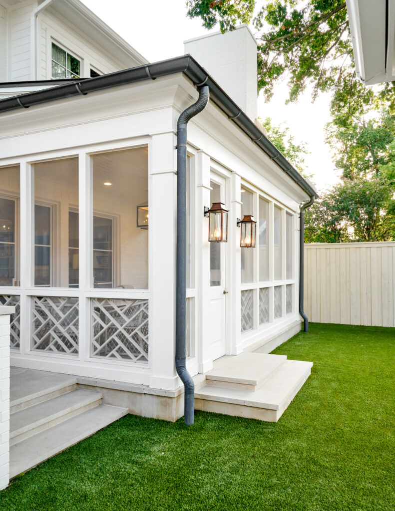 Custom patio with wood accent screens and white farmhouse styled porch with exterior lantern lights made by Gillis custom homes in dallas texas