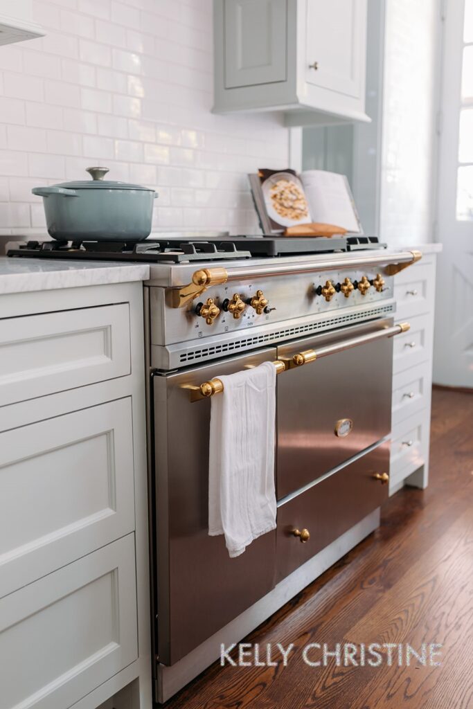 Recent project of a luxury custom home with a client chosen hand crafted cabinets, light blue painted trim over a beautiful range oven built by Gillis Custom Homes in Dallas Texas