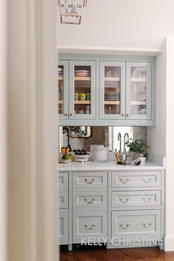 Recent project of a luxury custom home with a client chosen hand crafted dish cabinets, light blue painted trim over a beautiful bar with a renovated sink built by Gillis Custom Homes in Dallas Texas